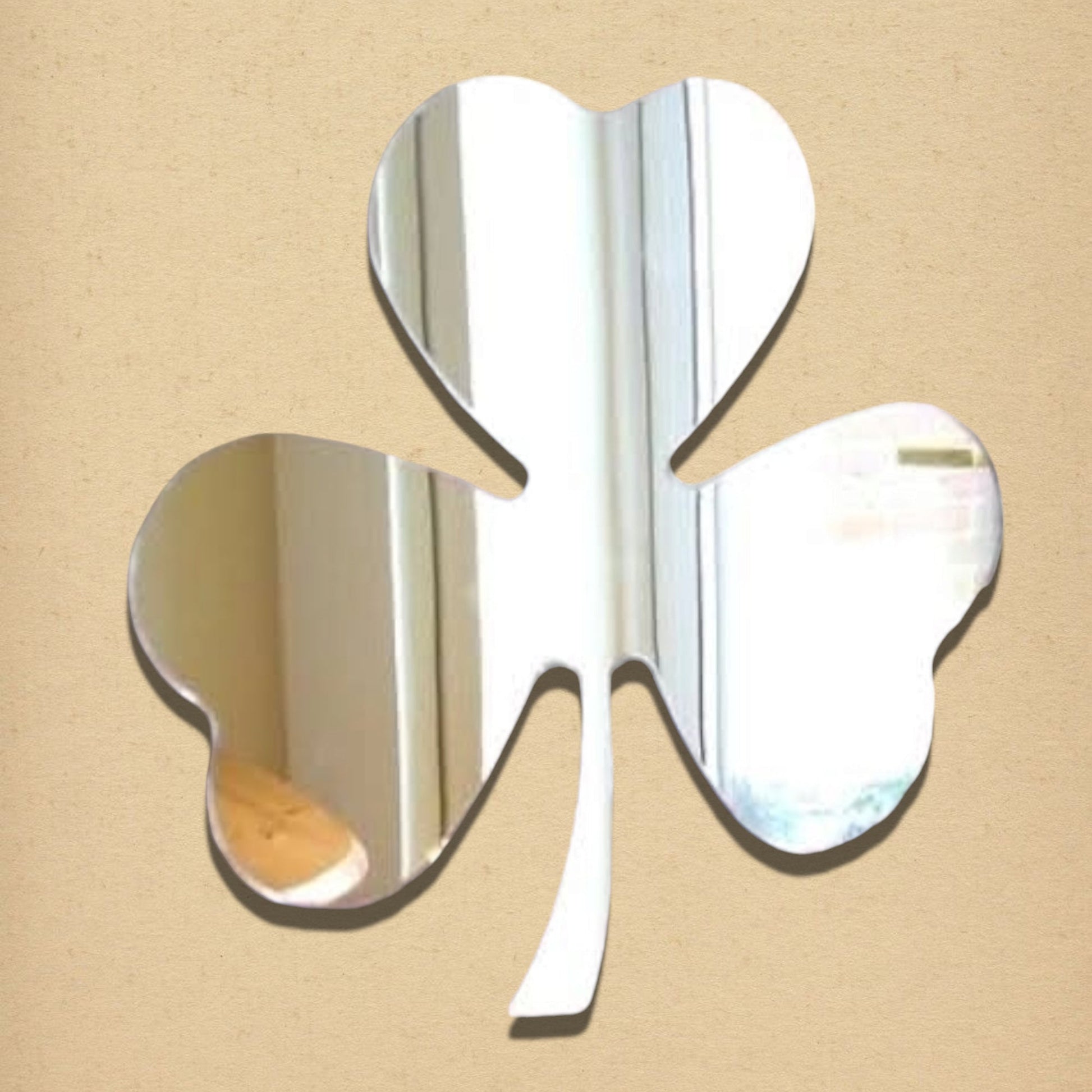 Clover Garden Mirror in the shape of a three-leaf shamrock with a stem, made of reflective mirrored glass.