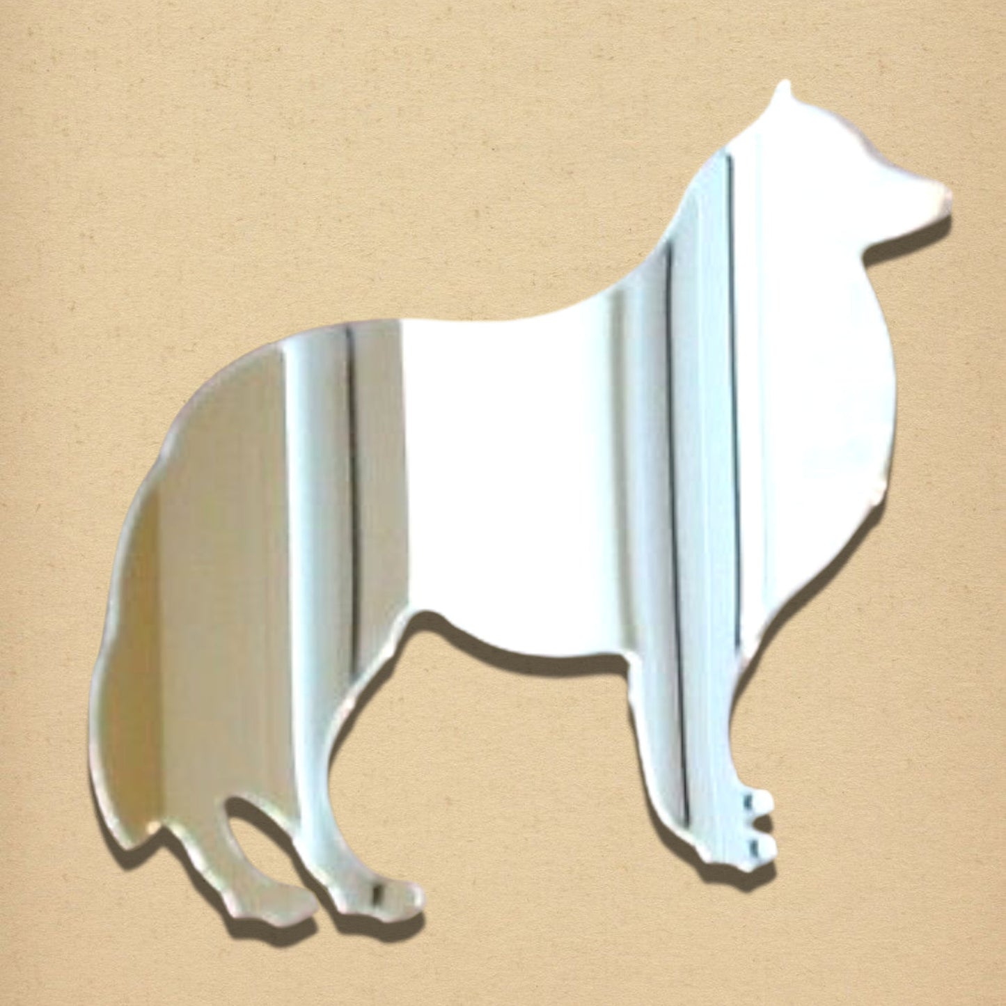 Collie-shaped silver mirror on a light tan textured background.