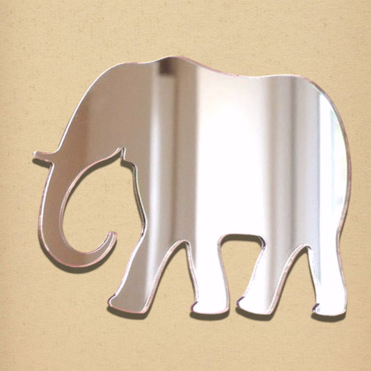 An elephant-shaped mirror with a reflective surface and pink edges on a tan background.