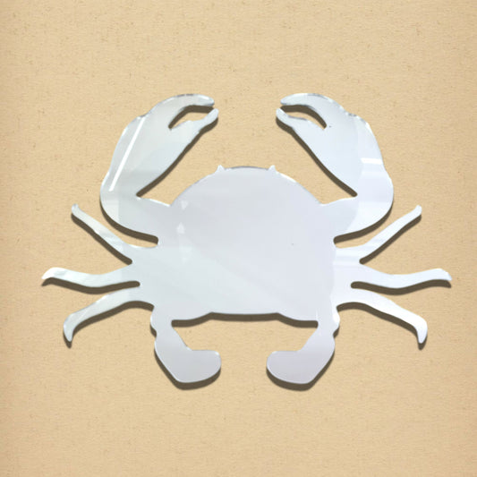 Silver crab-shaped mirror on a light brown background.