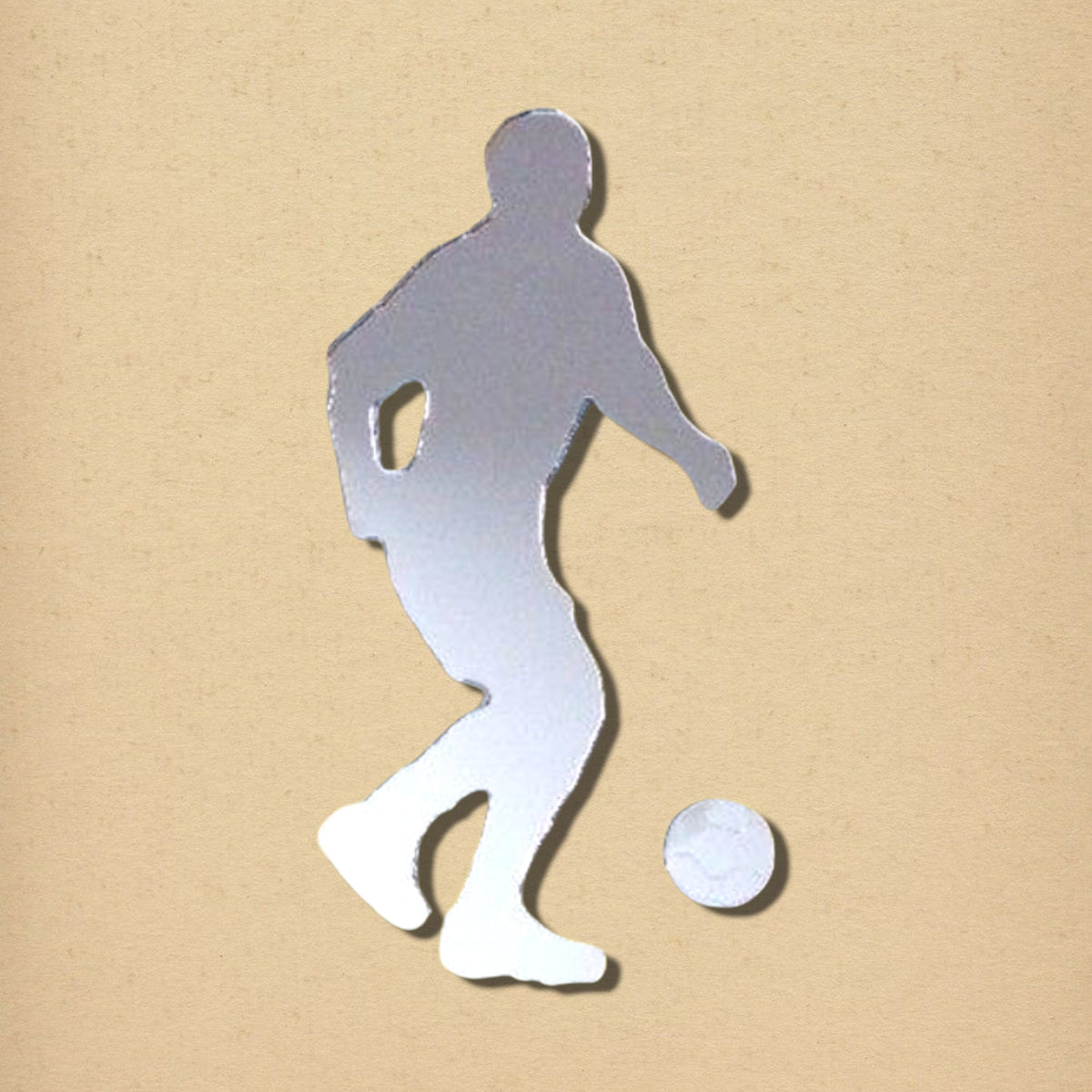 Silver mirrored wall sticker shaped like a male footballer dribbling a ball.