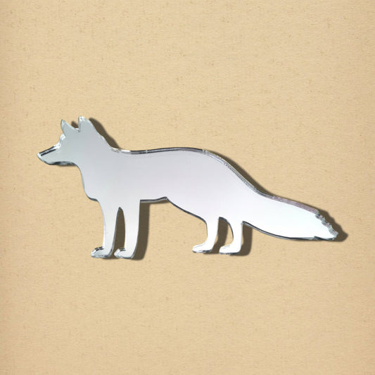 Fox-shaped mirror in silver glass on a textured beige background.