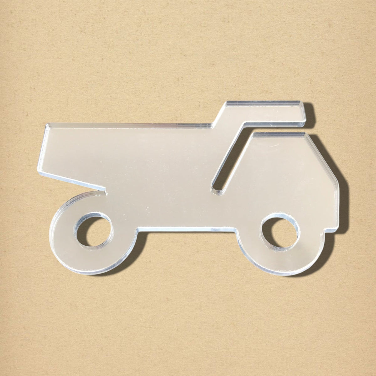 Silver acrylic dumper truck shaped mirror with two circular wheel cutouts.