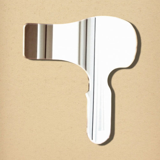 Hairdryer-shaped reflective mirror on a light beige background.