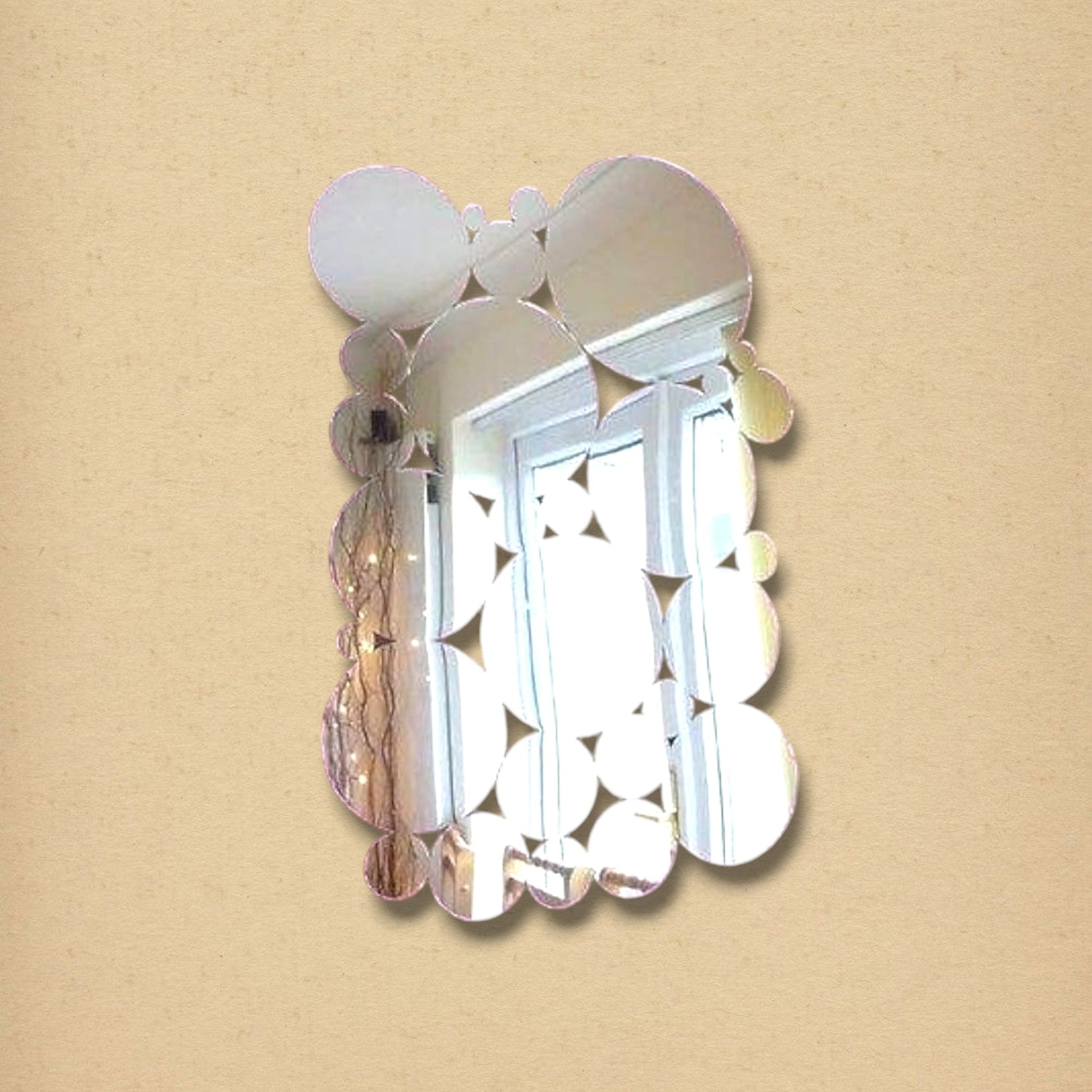 A vertical wall mirror composed of overlapping circular glass panels of varying sizes.