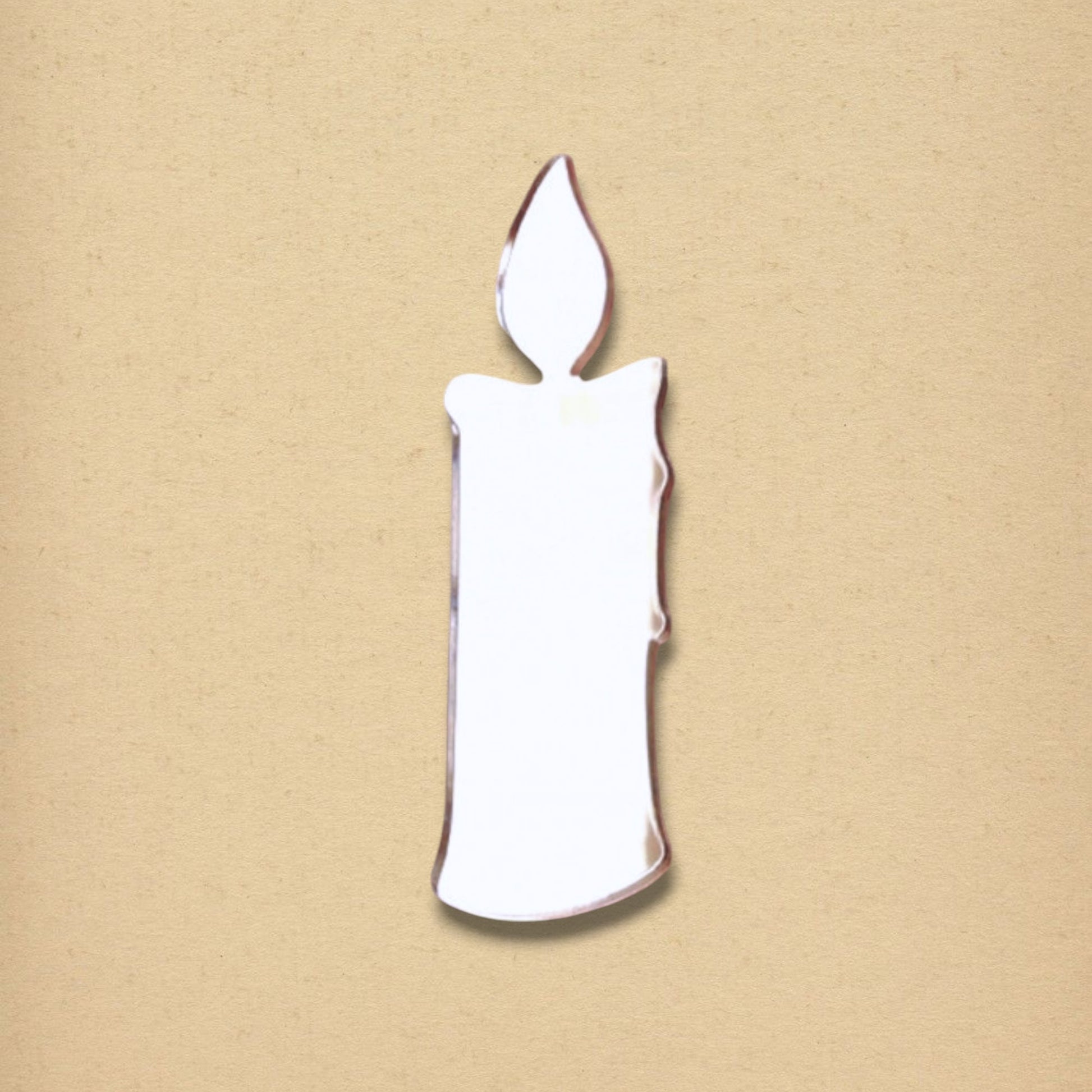 A candle-shaped mirror with a separate flame cutout, set against a neutral tan background.