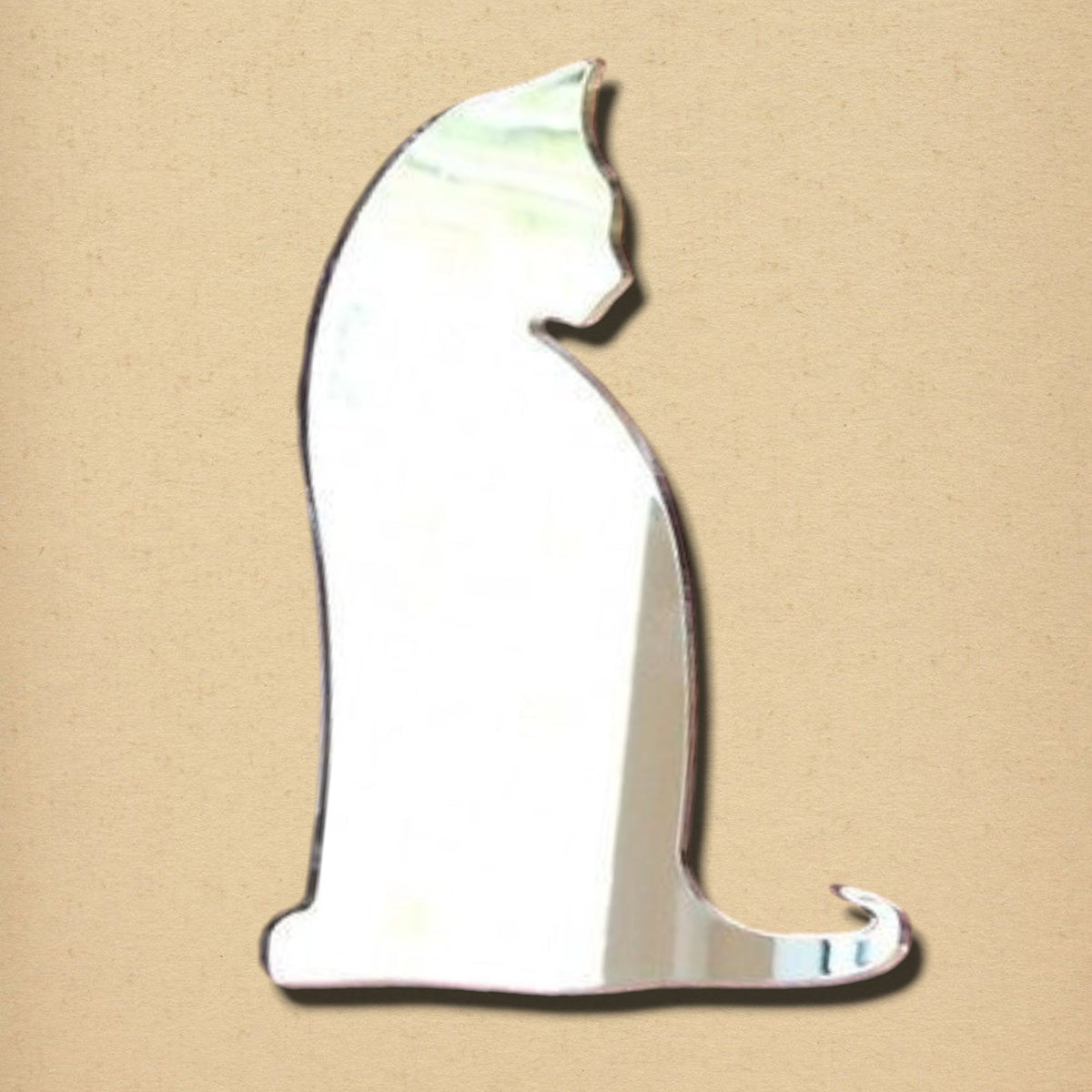 Cat-shaped mirror sitting upright on a plain beige background.