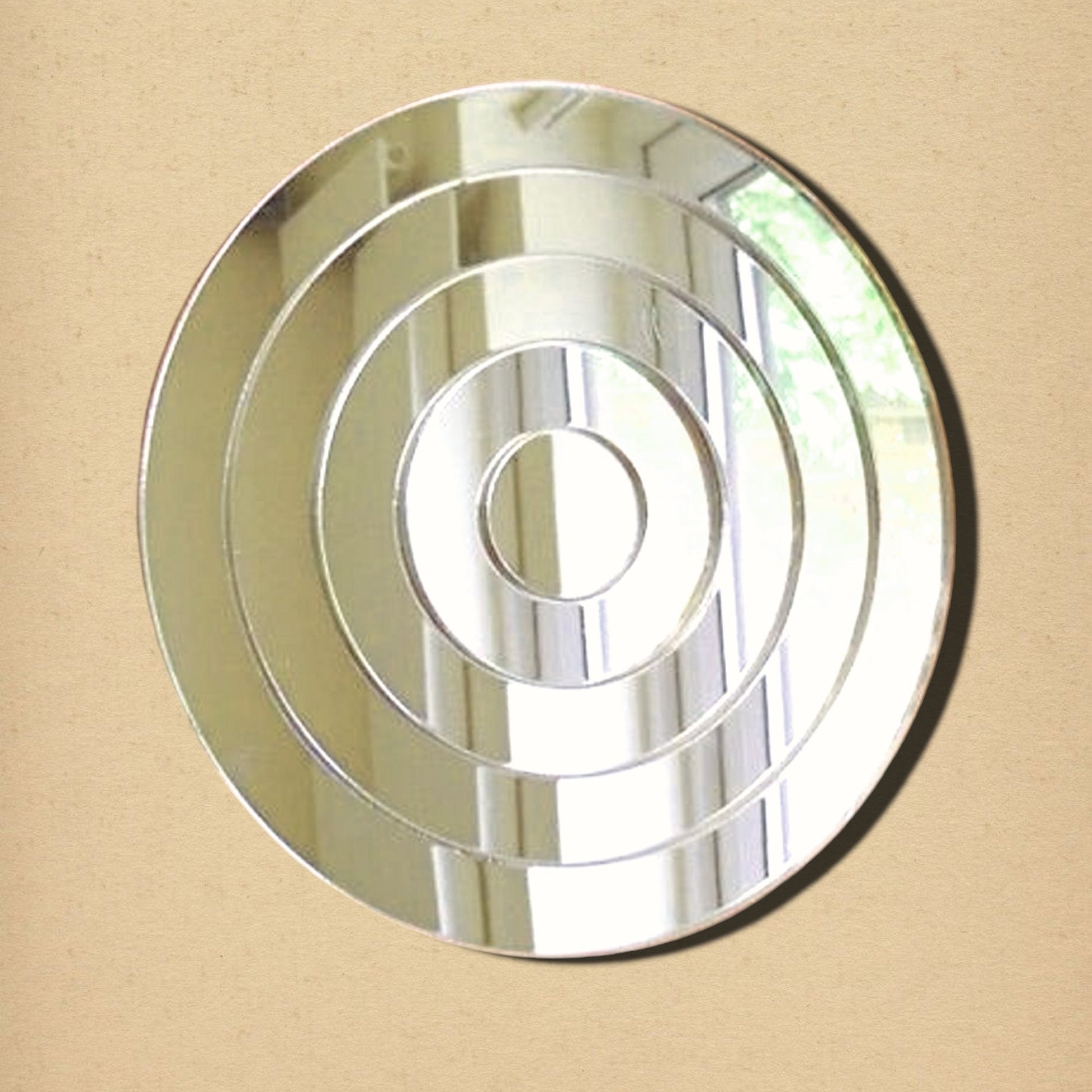 A round wall mirror with concentric circular bevels creating an infinite tunnel effect.