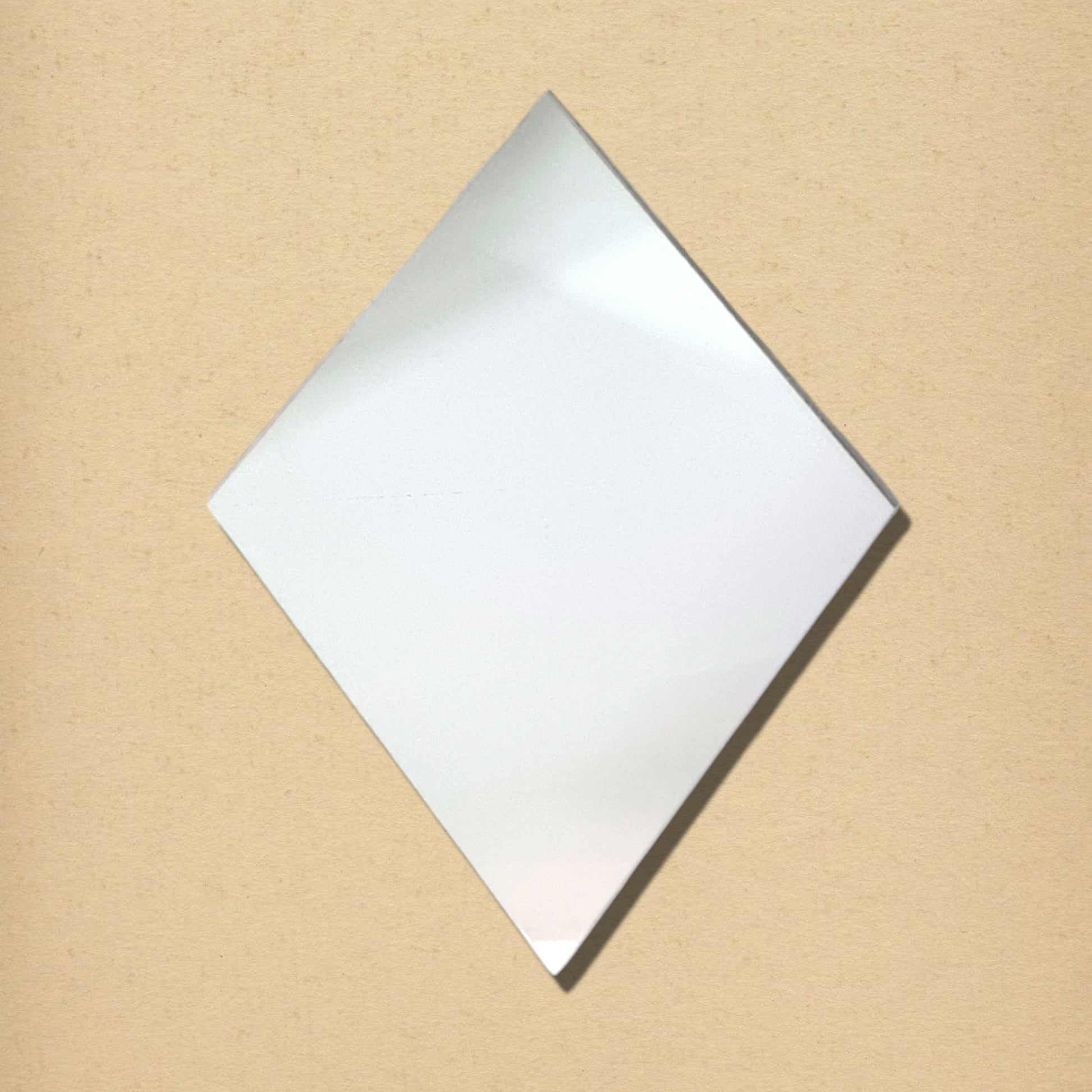 Diamond-shaped glass mirror on a textured beige background.