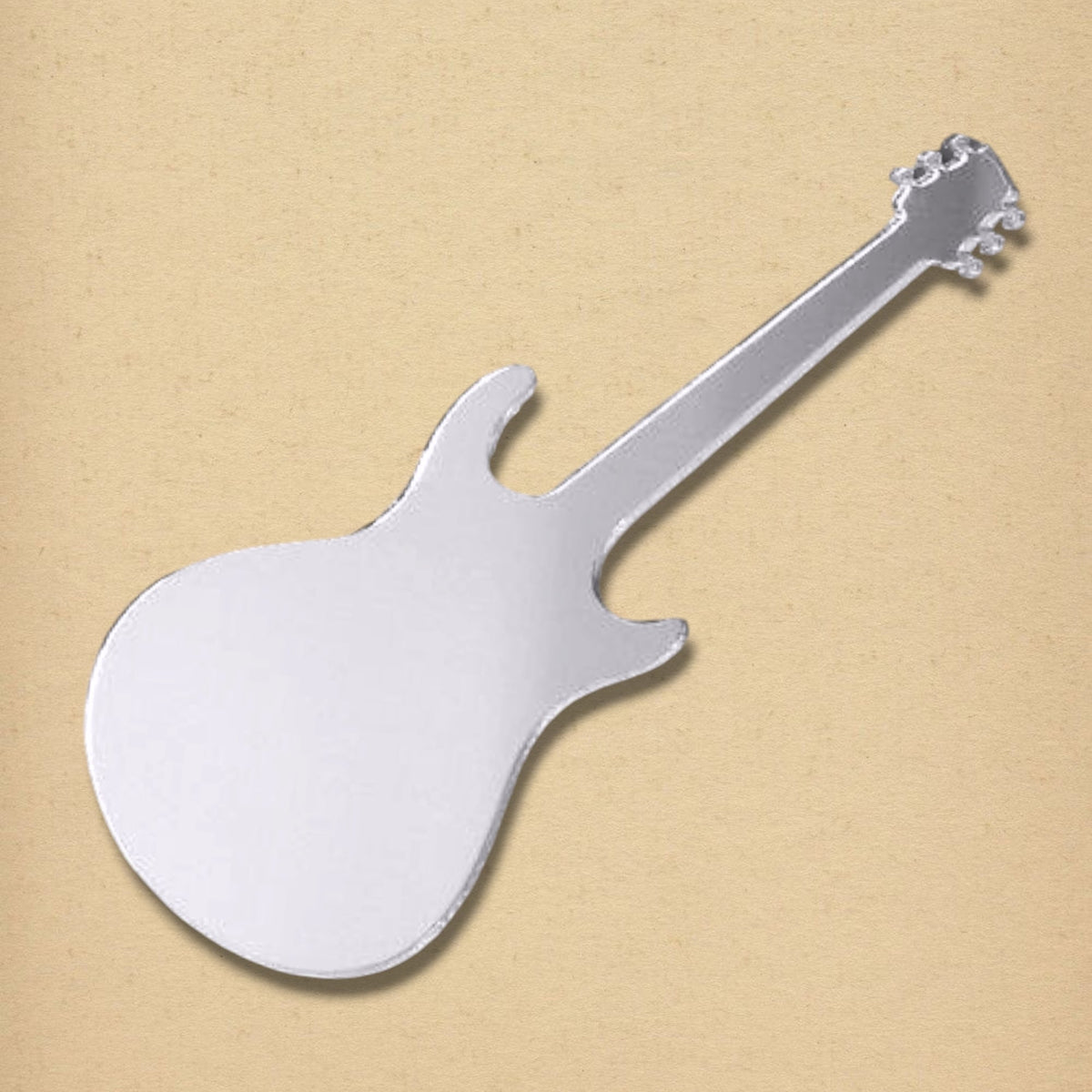 Silver electric guitar-shaped mirror on a textured tan background.