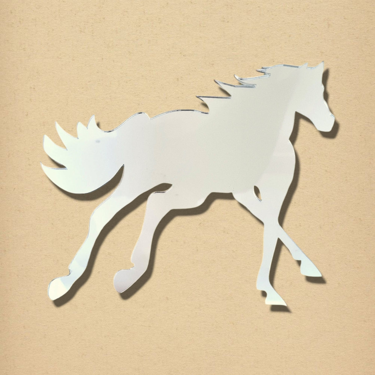 Silver horse-shaped mirror in a cantering pose against a textured beige background.