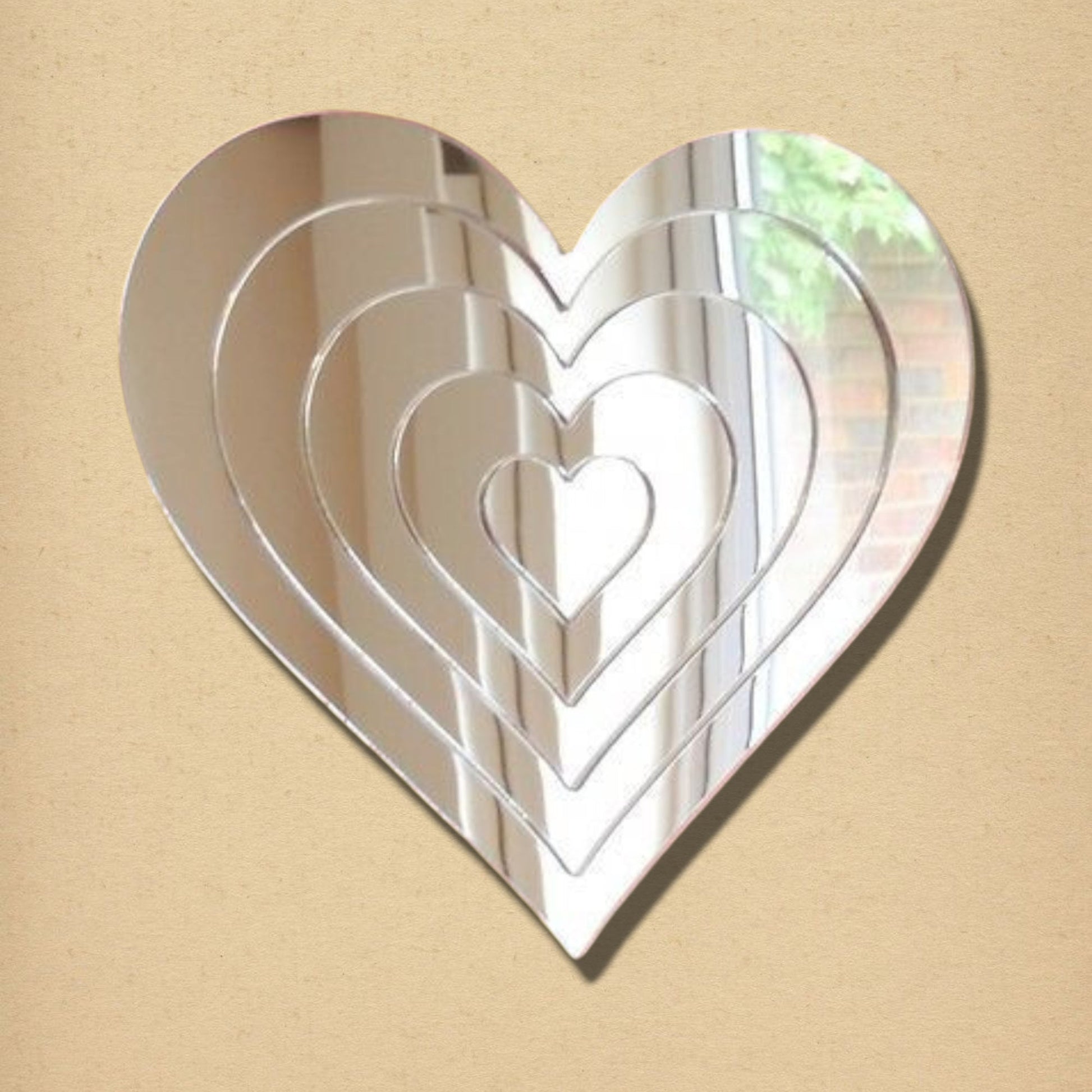 Heart-shaped silver mirror featuring a nested, concentric infinity heart design.