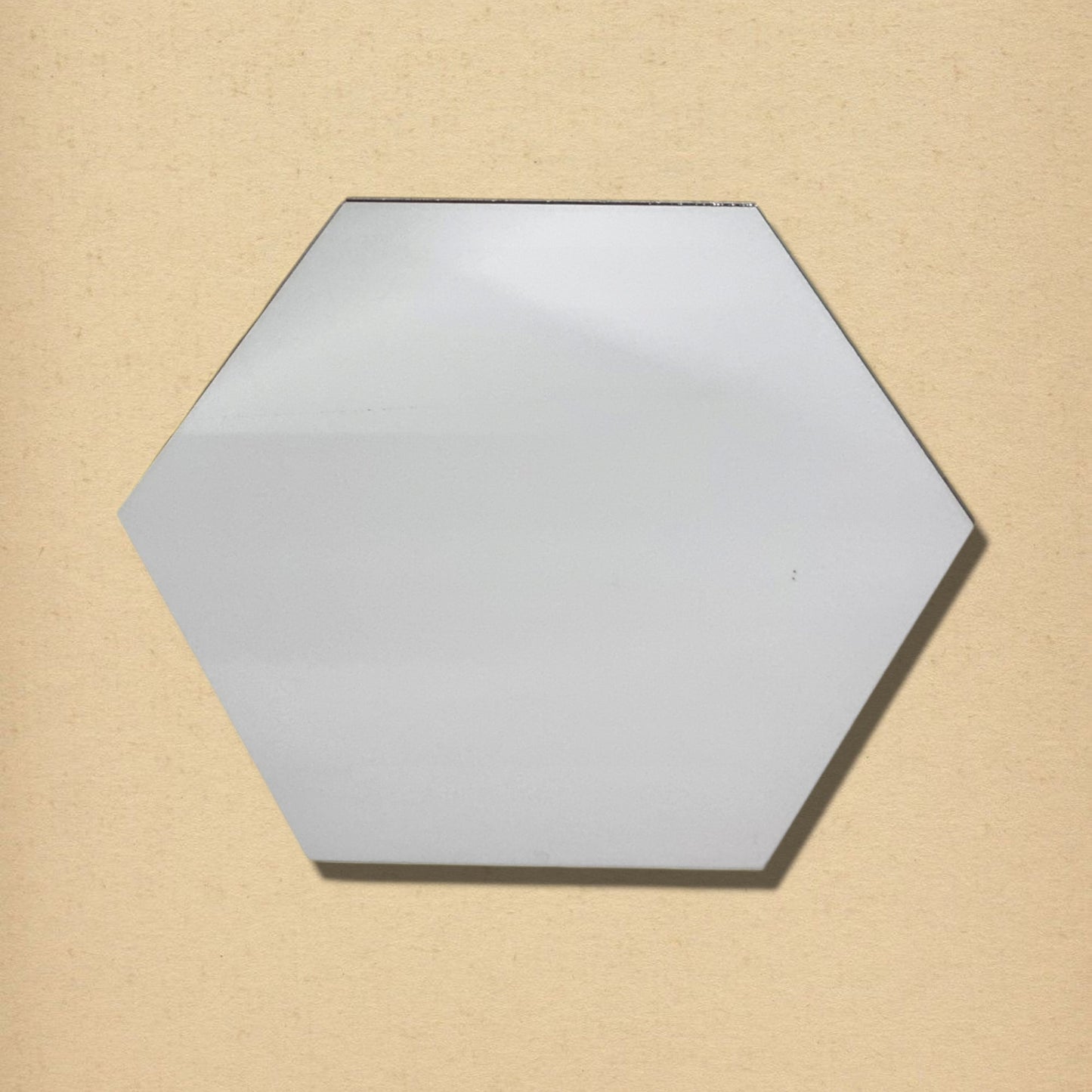 A single hexagonal glass mirror against a textured beige background.