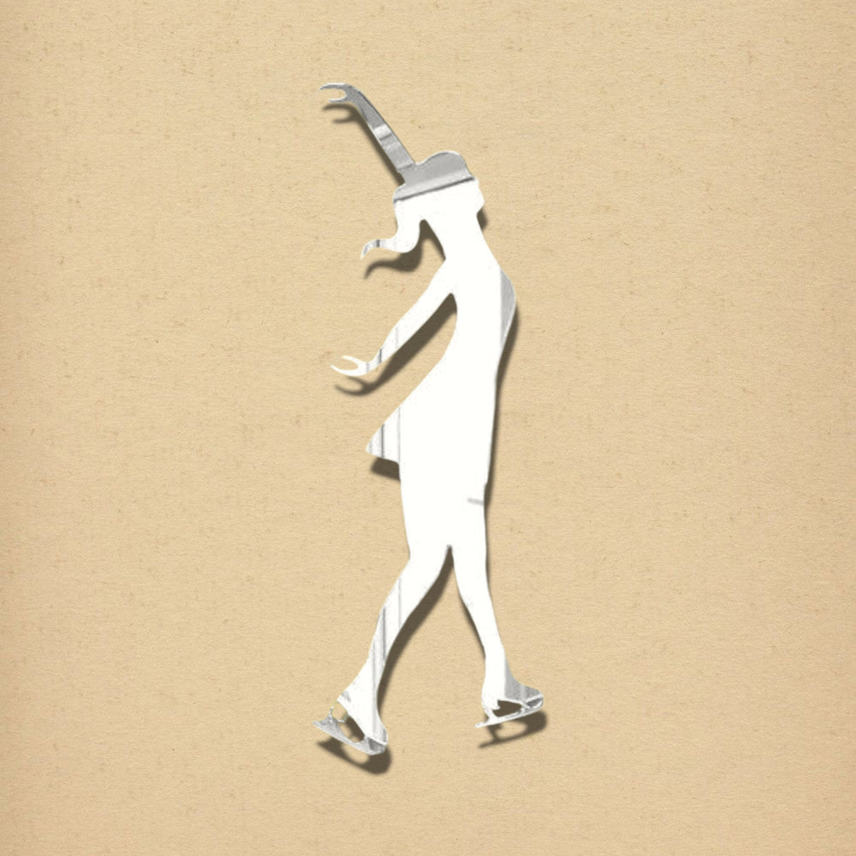 An ice skater shaped silver mirror against a beige textured background.