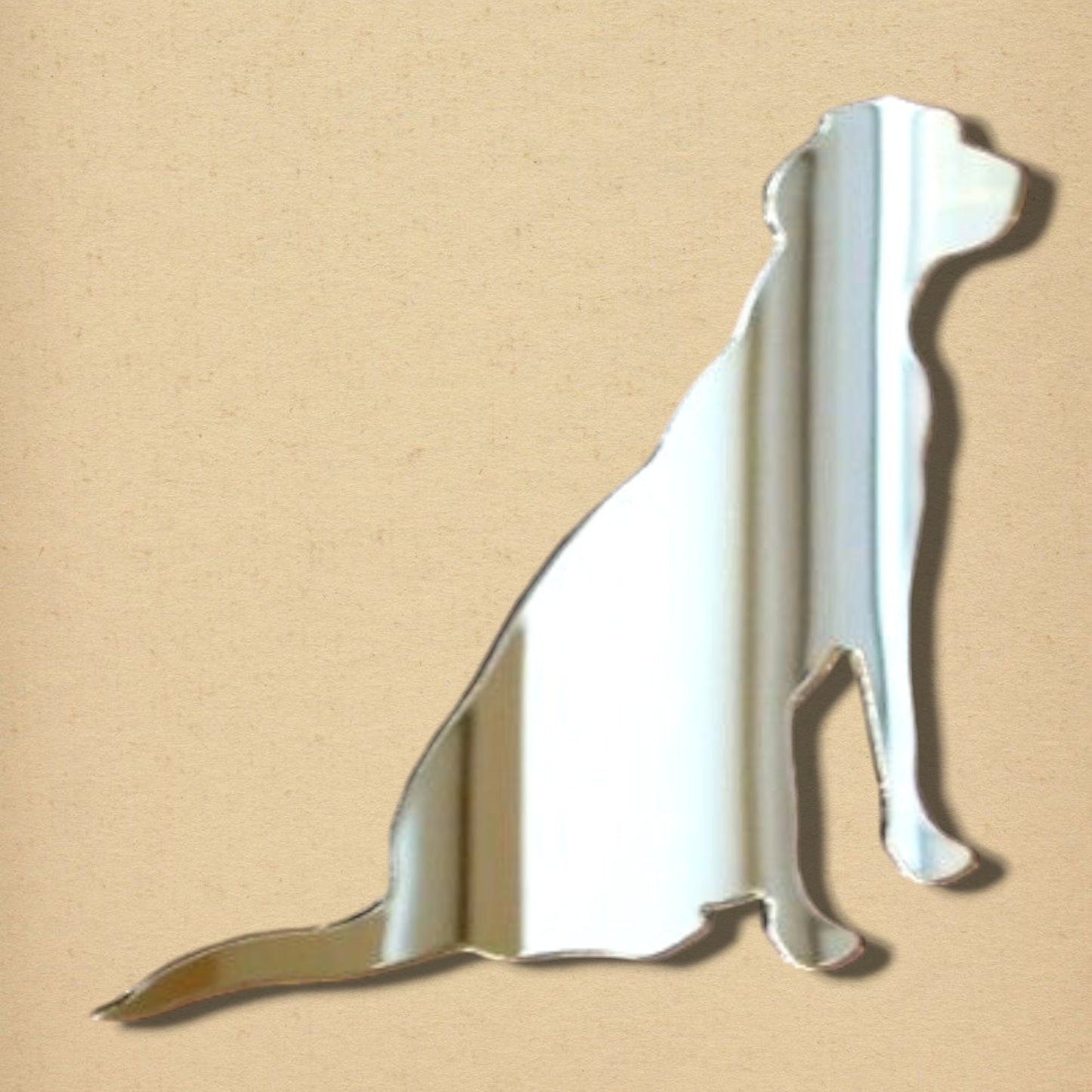 Labrador retriever-shaped reflective mirror on a light beige background.