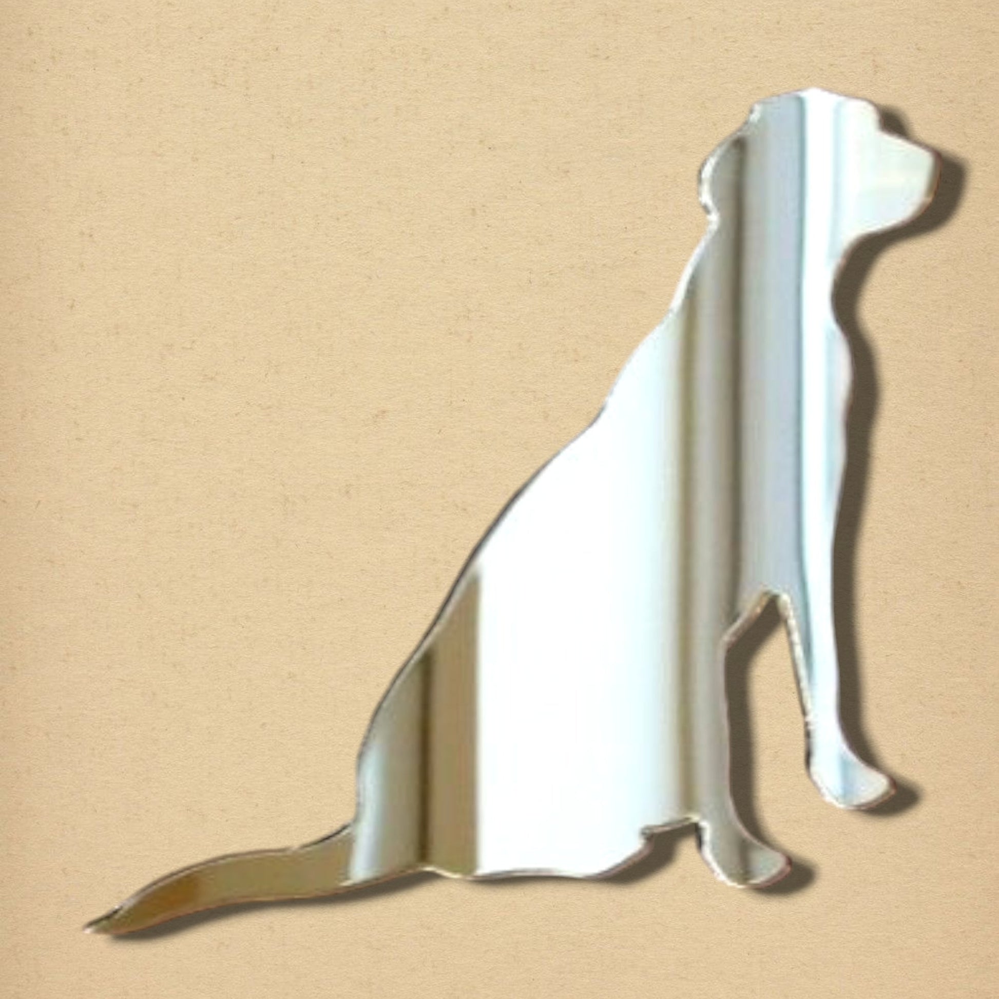 Labrador retriever-shaped reflective mirror on a light beige background.