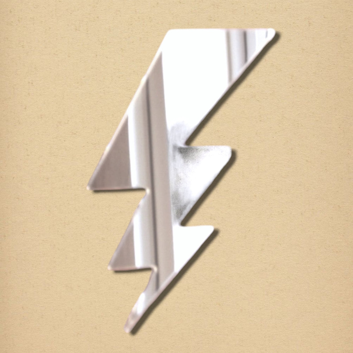 A silver lightning bolt-shaped mirror on a textured tan background.