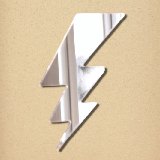 A silver lightning bolt-shaped mirror on a textured tan background.