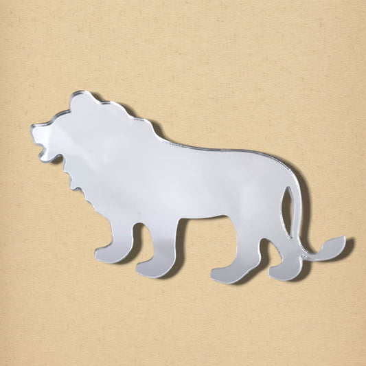 Lion-shaped acrylic mirror in reflective silver on a tan surface.