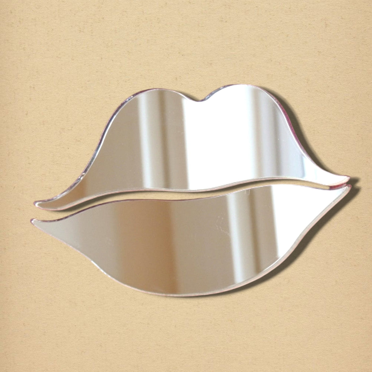Lips-shaped reflective mirror on a tan background.