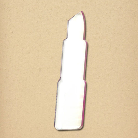 Lipstick-shaped mirror with a pink border on a textured tan background.