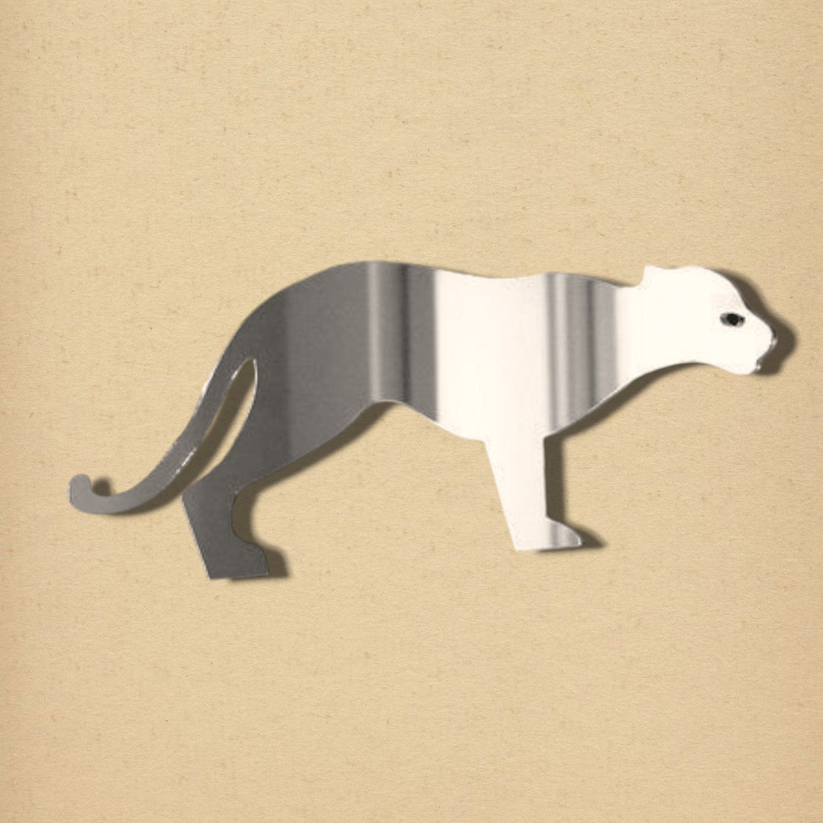 Silver cat-shaped wall mirror with reflective surface on a beige background.