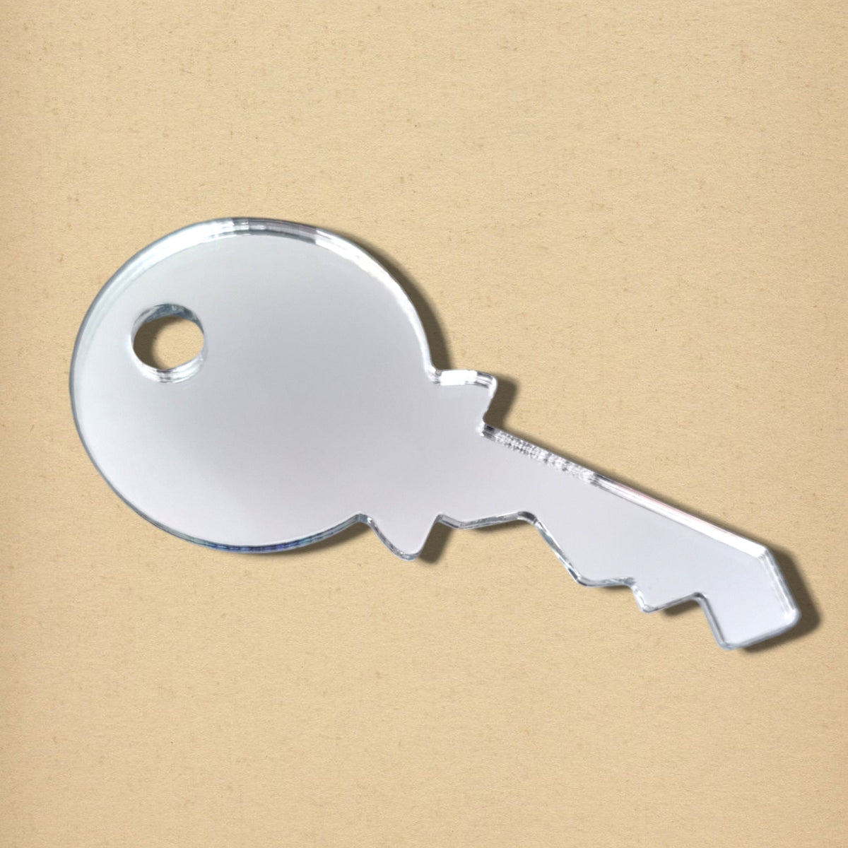 Yale-key-shaped acrylic mirror against a plain beige background.