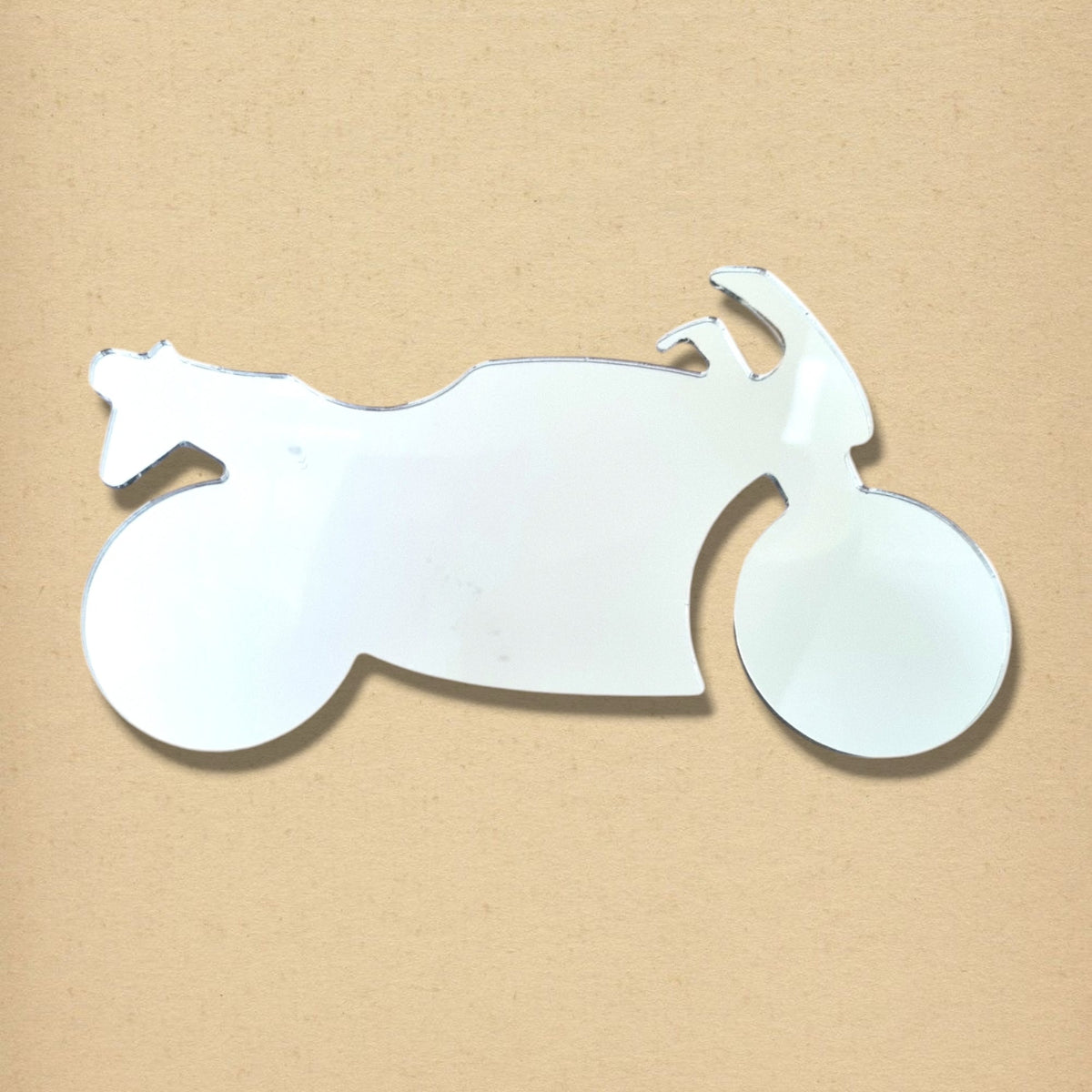 Motorbike-shaped reflective mirror on a tan textured background.