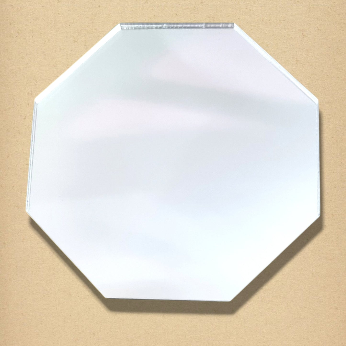 An octagon mirror with a beveled edge, shown against a neutral beige background.