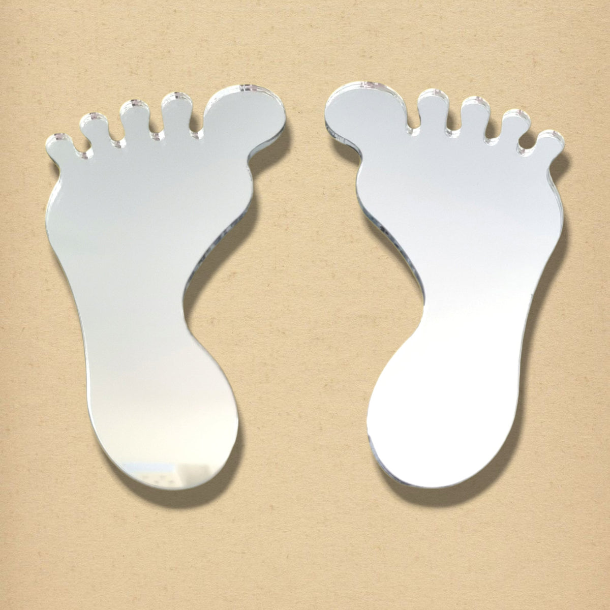 A pair of foot-shaped silver mirrors on a neutral background.