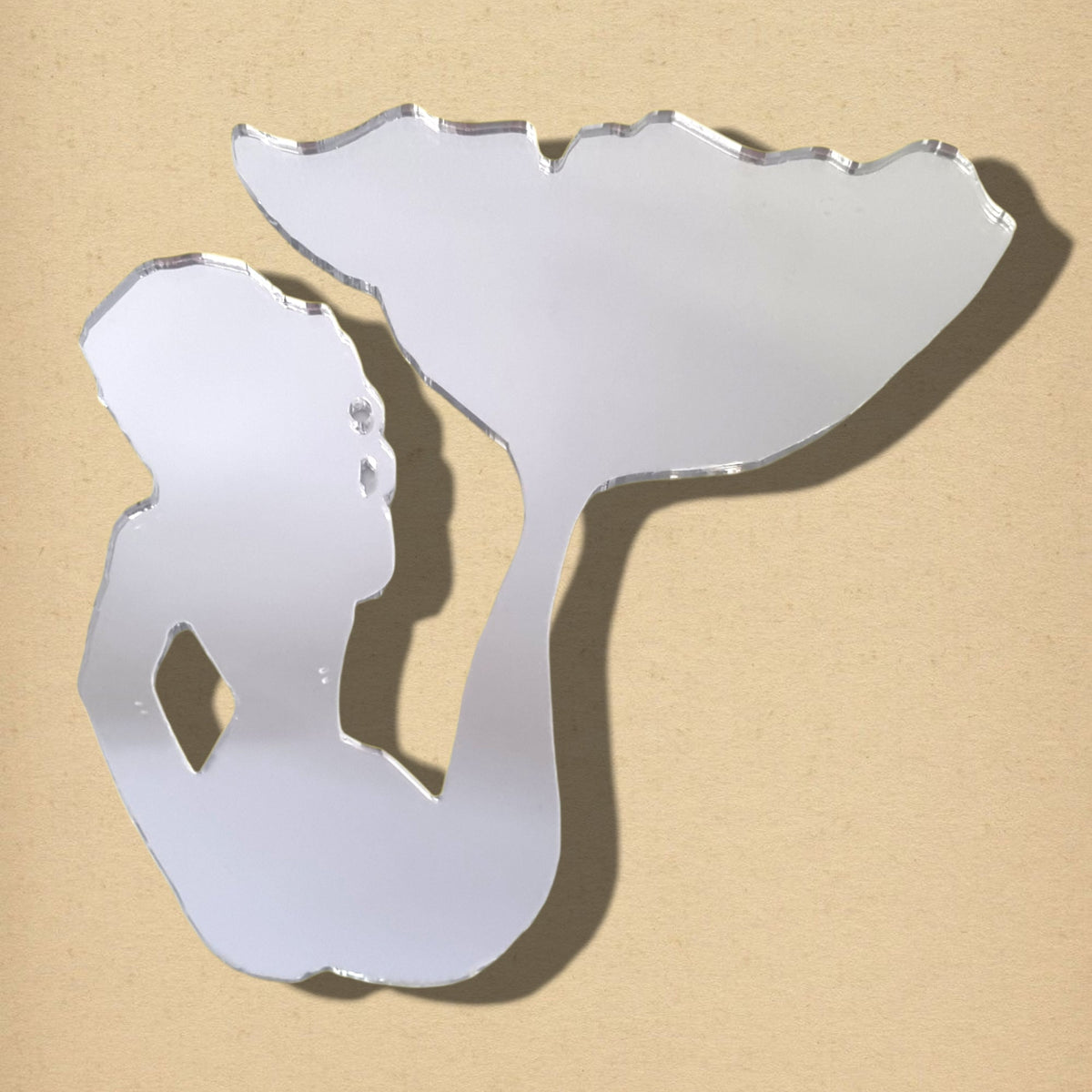 Mermaid-shaped acrylic mirror sitting against a beige background.