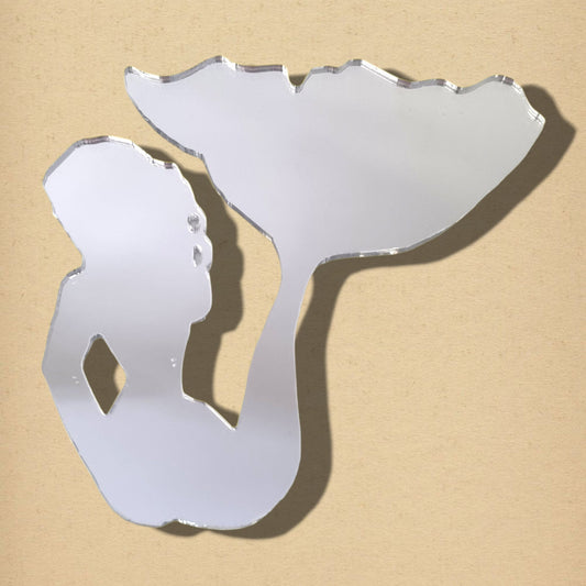 Mermaid-shaped acrylic mirror sitting against a beige background.