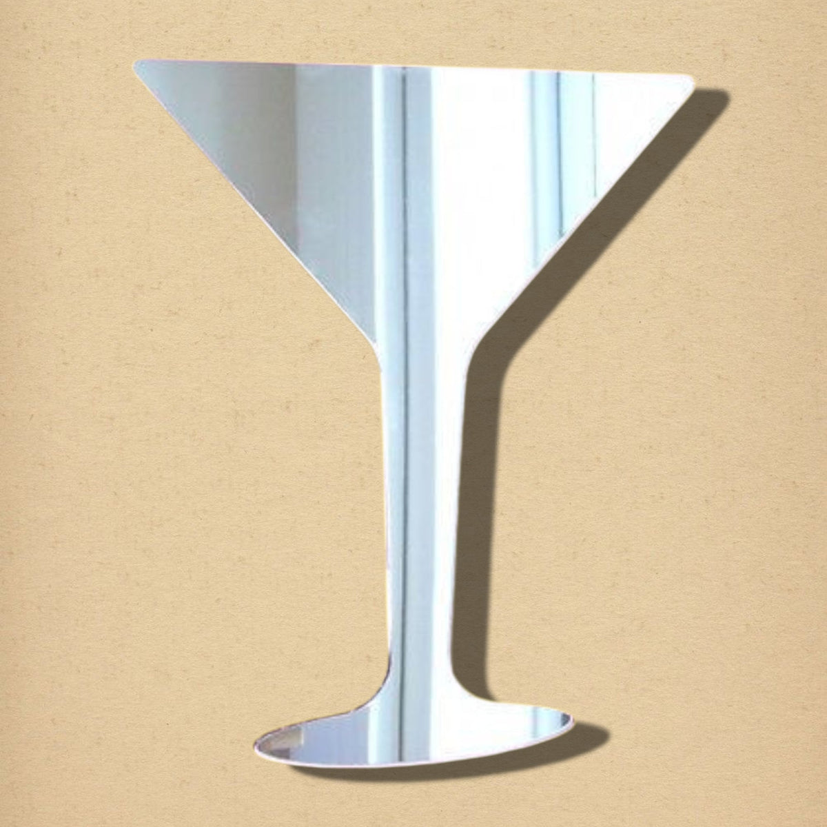 Martini glass-shaped silver mirror on a light brown background.