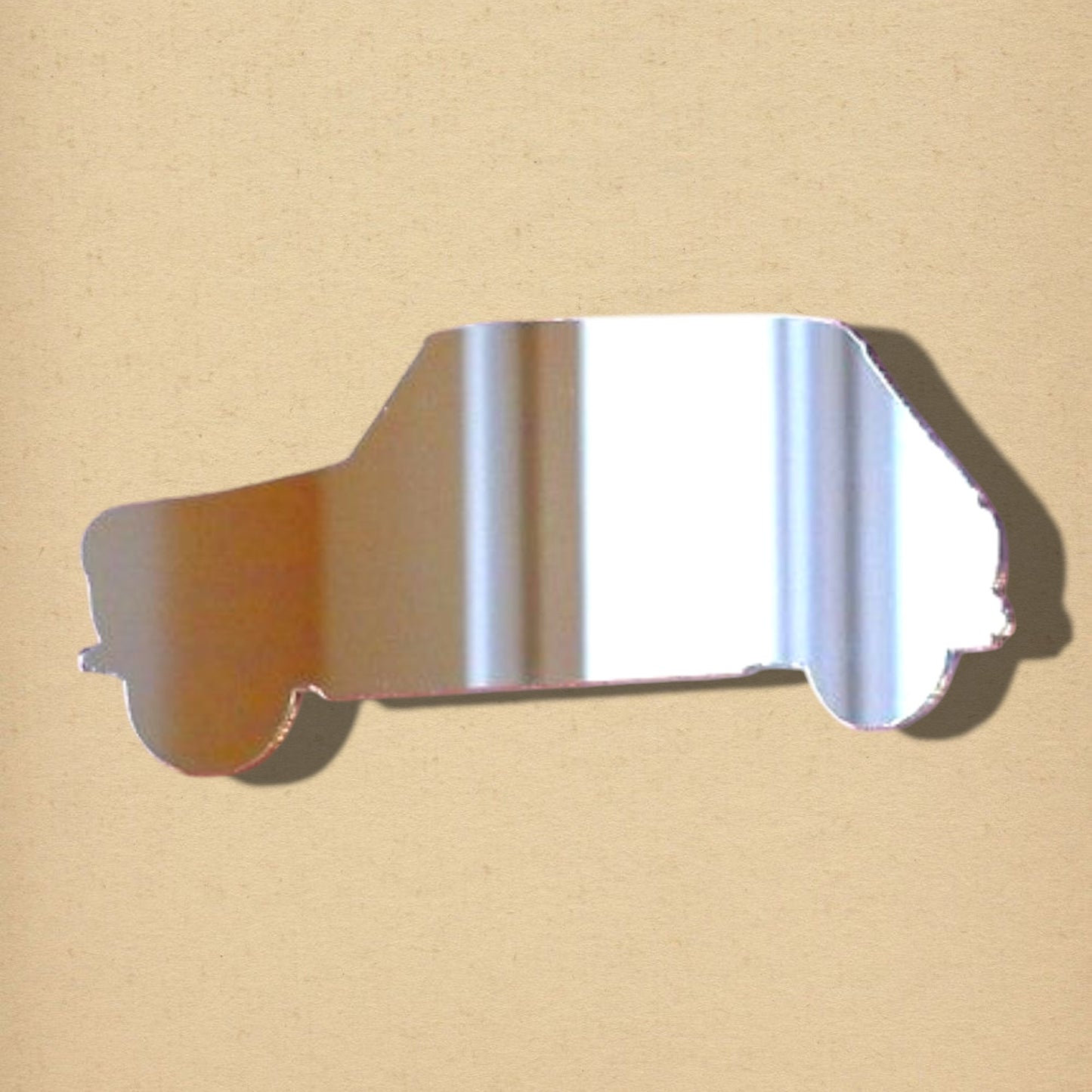 A silver, reflective mirror cut into the shape of a classic mini car.