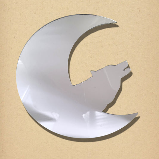 Silver crescent moon mirror shaped to feature a howling wolf silhouette against a tan background.