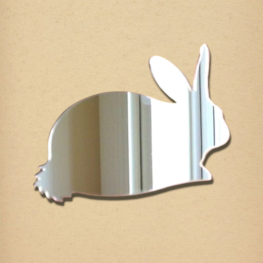 Rabbit-shaped silver wall mirror against a light brown background.