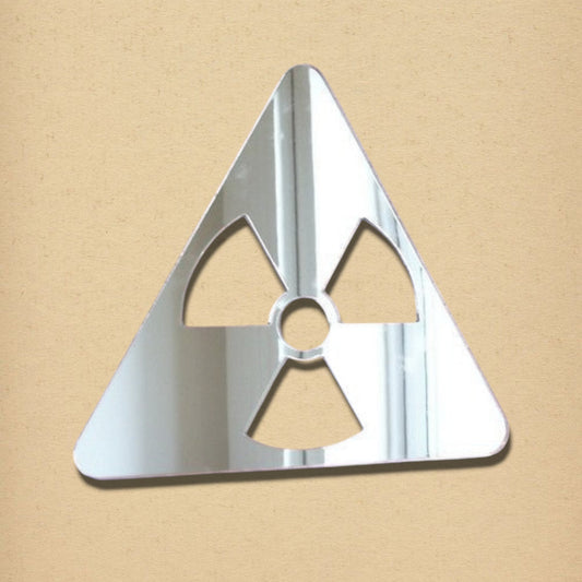 Silver acrylic radiation symbol mirror on a tan textured background.