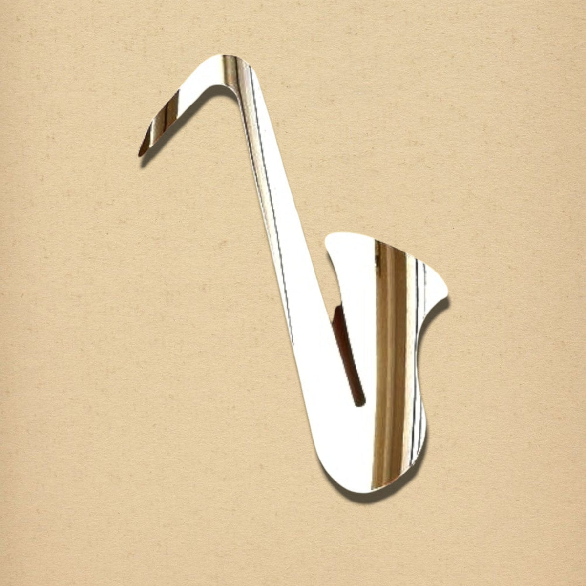 Silver saxophone-shaped mirror on a textured beige background.