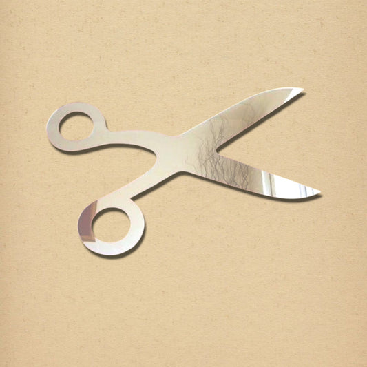 A silver scissors-shaped mirror on a textured beige background.