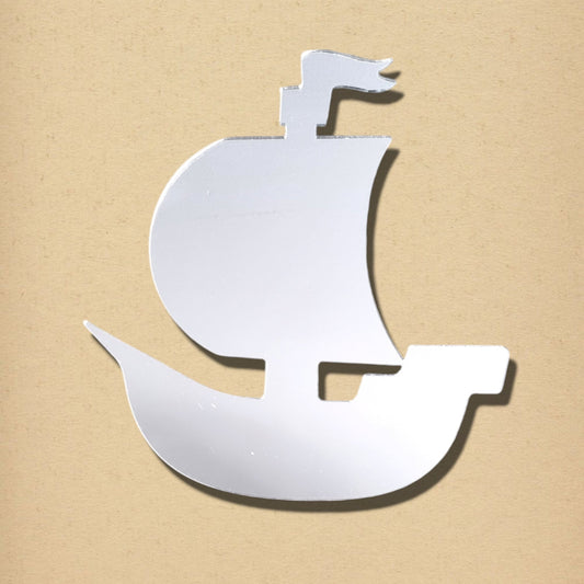 Silver pirate ship shaped mirror on a tan background.