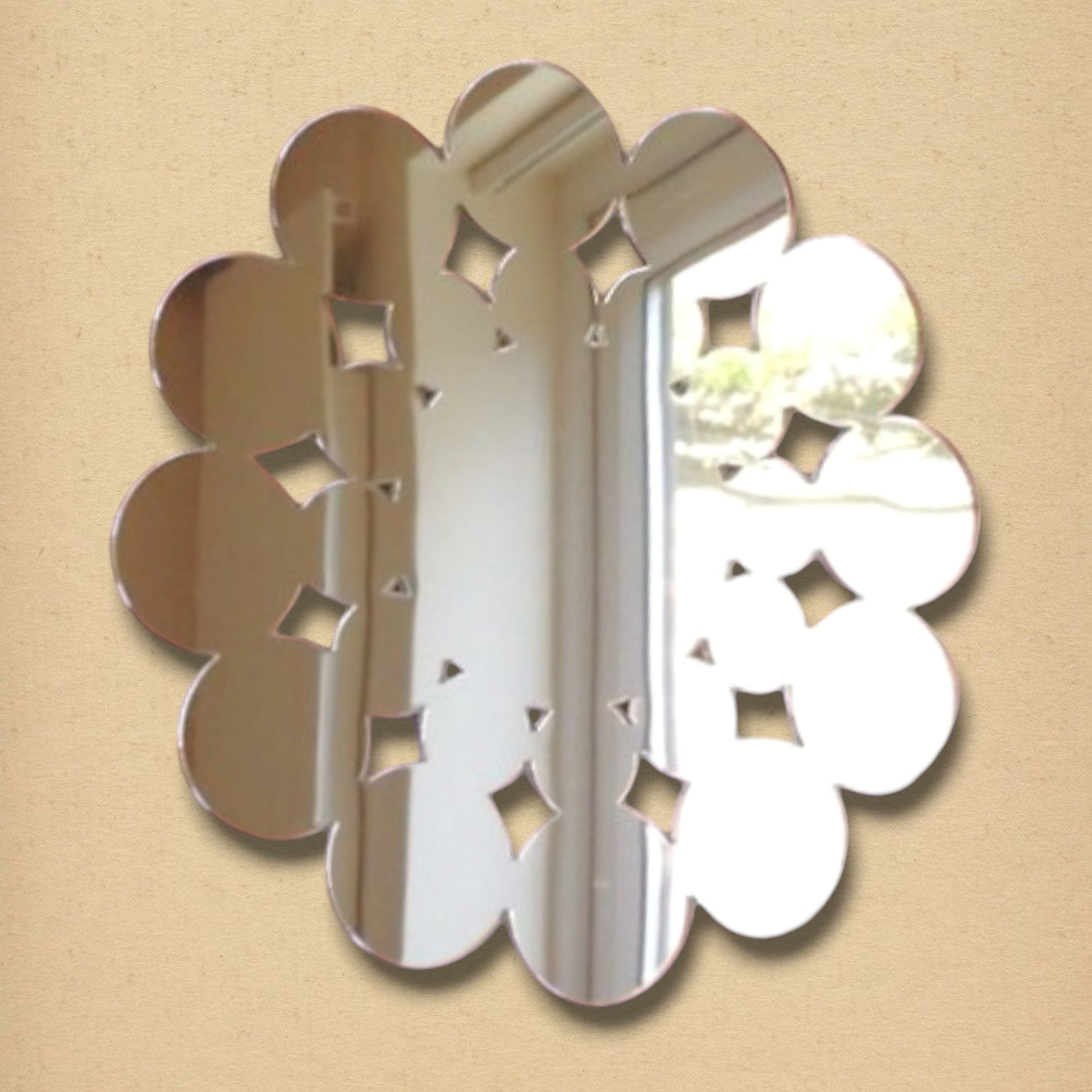 A round decorative mirror featuring a scalloped edge and geometric cutout patterns.
