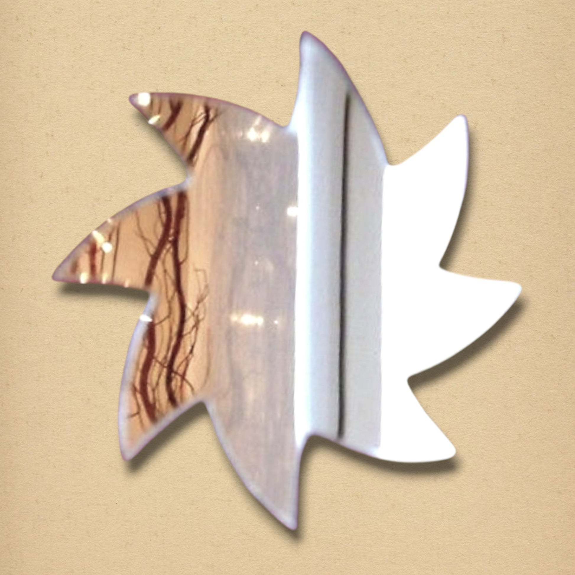 Spiral Star Mirror with a metallic finish, shaped like a seven-pointed star with curved points, reflecting a brown and white scene.