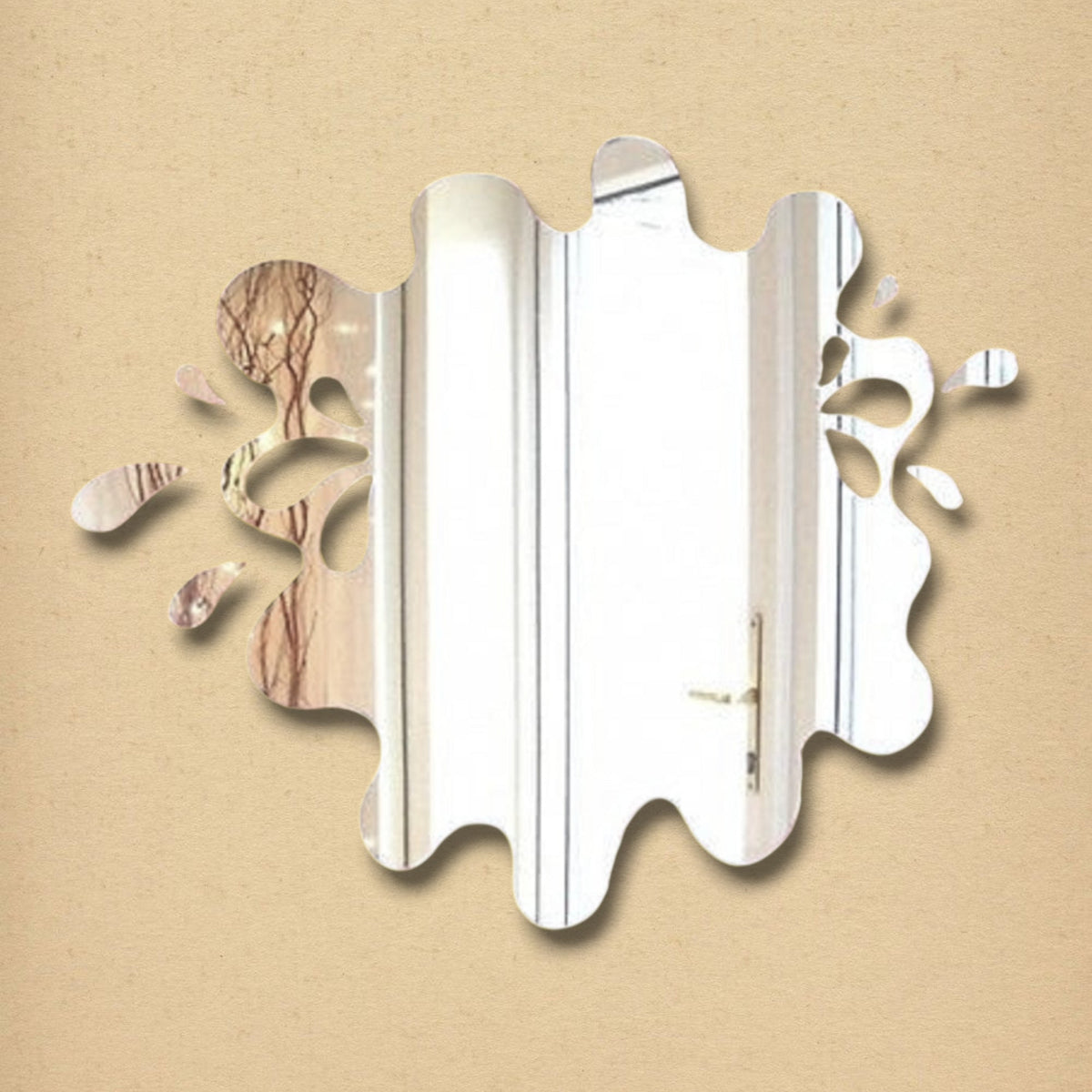 An irregular water-splash-shaped wall mirror with reflective surface against a plain tan background.