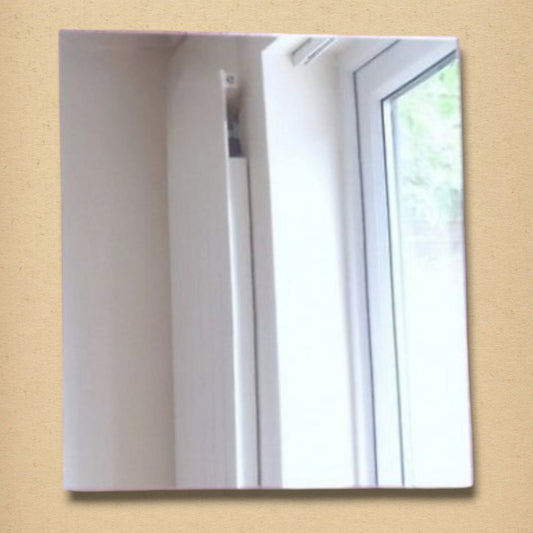 A frameless square mirror reflecting a white wall and window.