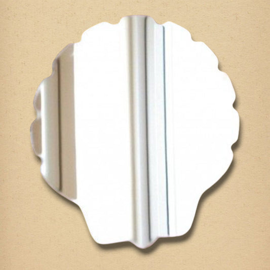 Shell-shaped mirror with a scalloped edge on a tan background.