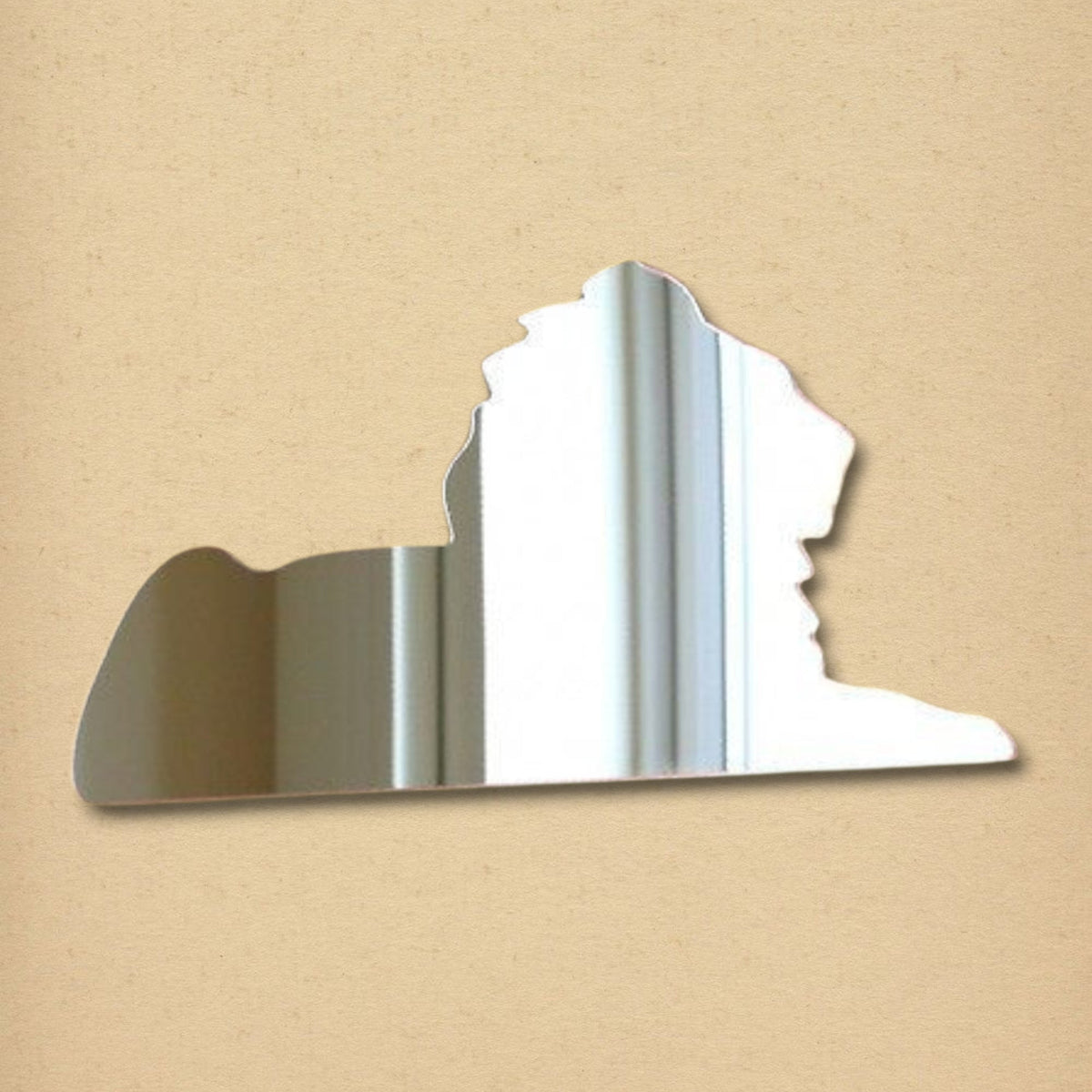 Sphinx-shaped silver mirror on a textured tan background.