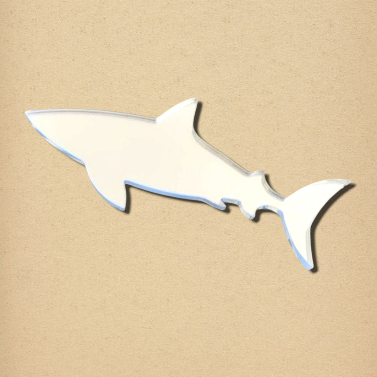 Shark-shaped mirror on a textured beige background.