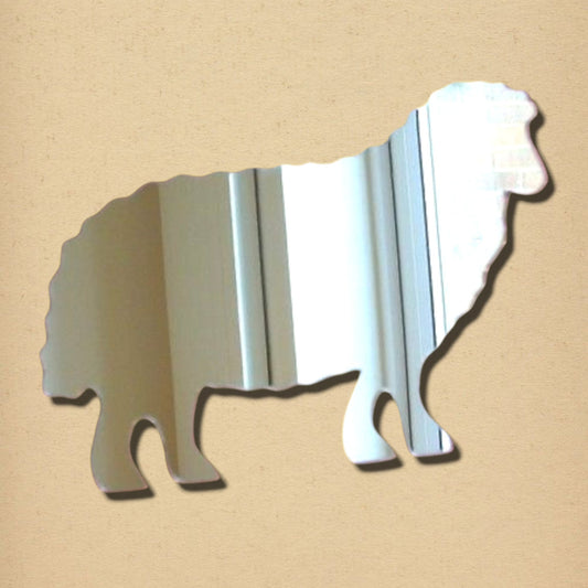A silver sheep-shaped mirror on a textured tan background.