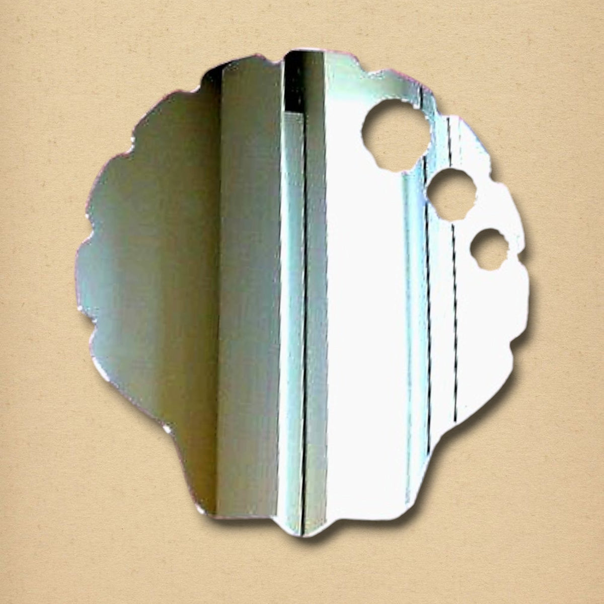 Irregular, scalloped-edge silver mirror with three circular cutouts, displaying a room reflection.