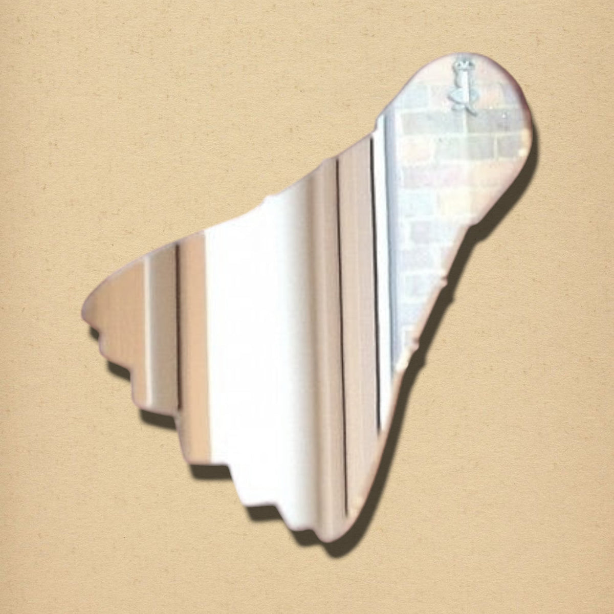 Shuttlecock-shaped mirror with a reflective surface, presented on a textured beige background.
